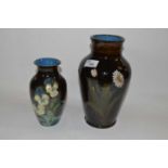 A pottery vase with an impasto type design of flowers together with a similar vase, largest 27cm