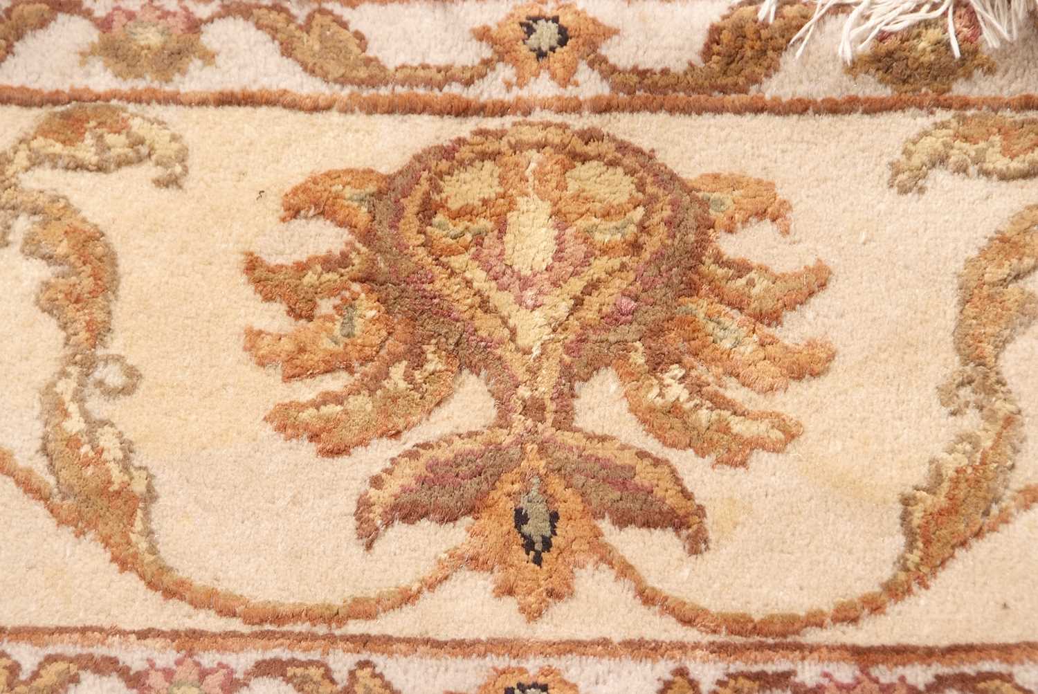 A 20th Century wool floor rug decorated with a stylised floral design on a cream and taupe - Image 15 of 16