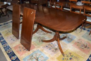 A large Georgian style mahogany veneered triple pedestal dining table with two extension leaves,