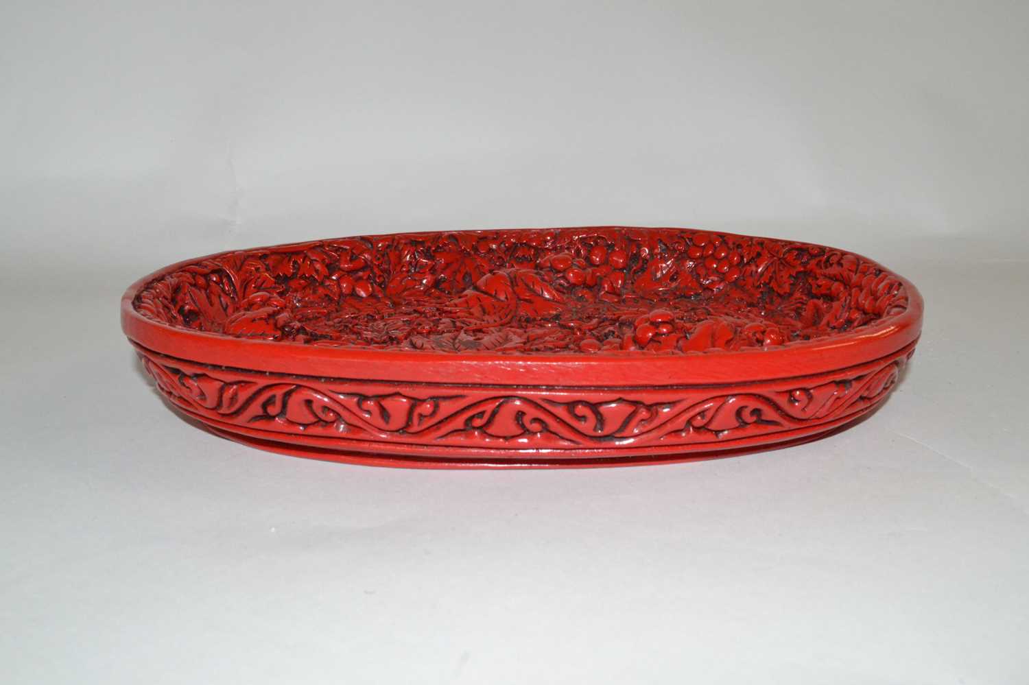 A Chinese red lacquer dish with raised relief decoration of berries and leaves, seal mark to base, - Image 2 of 4