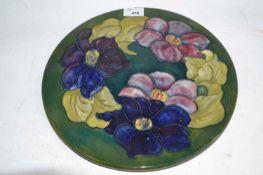 A Moorcroft charger, the green ground decorated with the anemone pattern, factory mark and paper