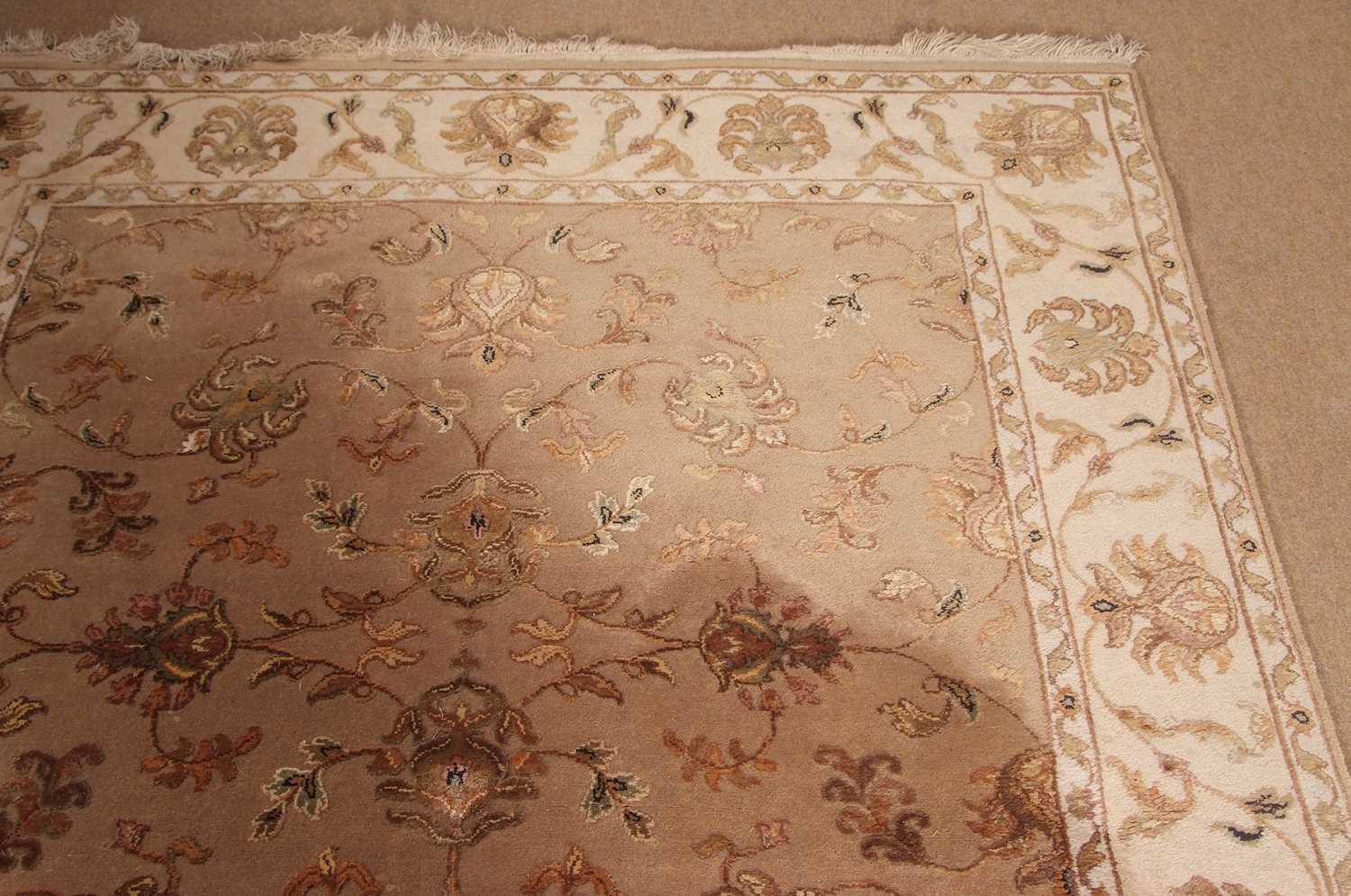 A 20th Century wool floor rug decorated with a stylised floral design on a cream and taupe - Image 4 of 16
