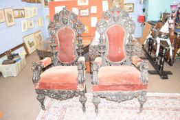 A pair of large 19th Century gothic style throne type chairs with elaborately carved backs and arms,