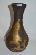 A Japanese iron vase of baluster form decorated in relief in gilt with a sinuous dragon amongst