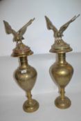 A large pair of brass vases with Islamic style decoration with onyx covers and eagle finials, 68cm