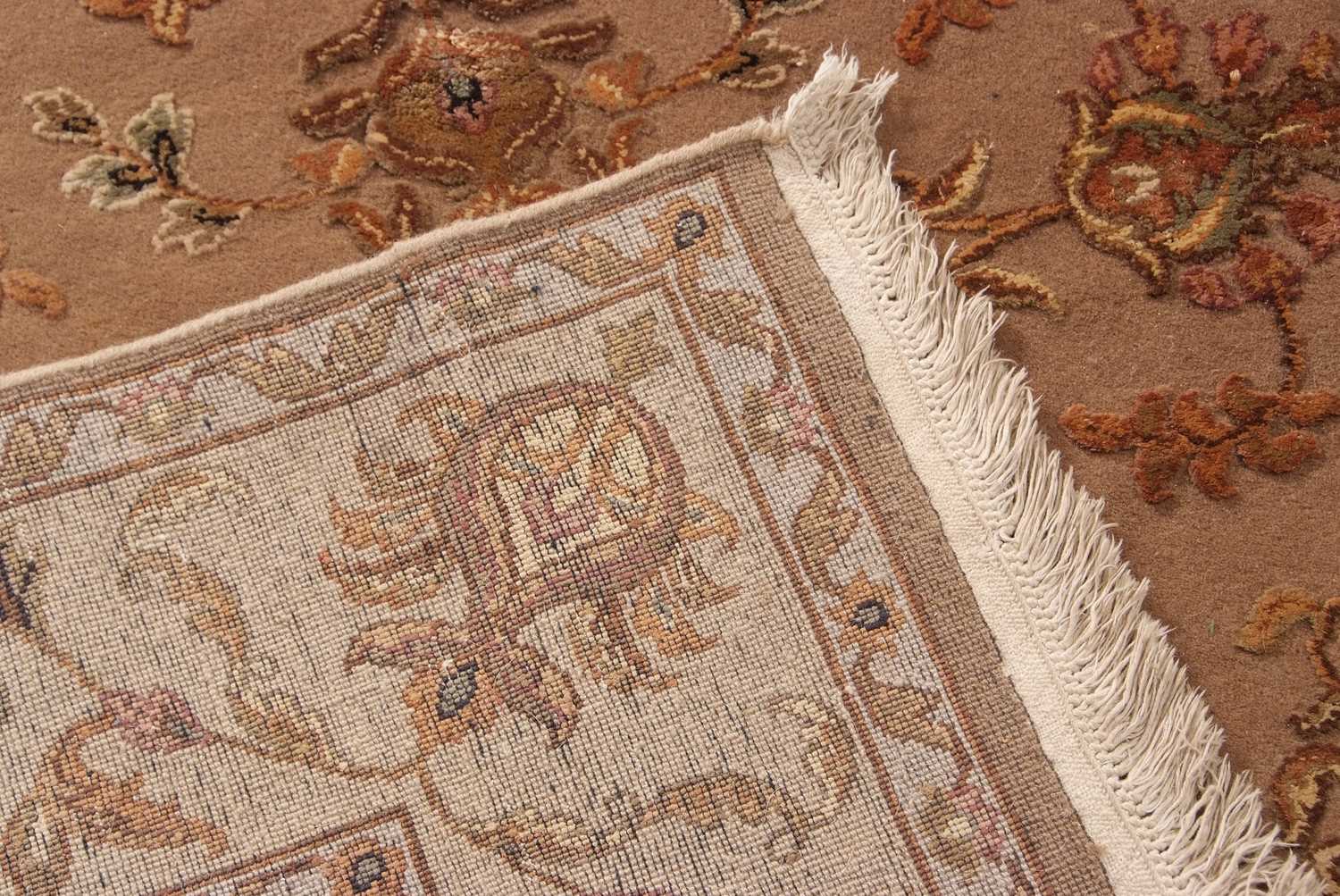 A 20th Century wool floor rug decorated with a stylised floral design on a cream and taupe - Image 5 of 16