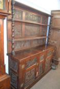An oak dresser with two shelf back and two door base incorporating 18th Century carved oak panels,
