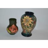 A small Moorcroft vase decorated with Hibiscus on a green ground together with a further Moorcroft