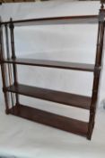 Victorian mahogany four tier wall shelf with turned side supports, 76cm wide