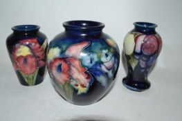 Group of three small Moorcroft vases, the blue ground with an orchid design, one of globular form (