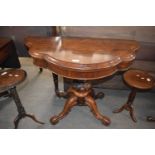 A Victorian rosewood tea table with shaped folding top over a bulbous column and four outswept legs,