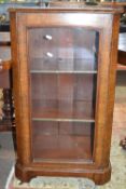 A Victorian walnut veneered music cabinet of typical form with glazed door and plinth base, 95cm