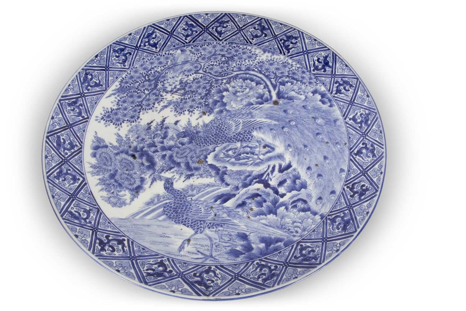 A large Japanese charger, Meiji period decorated in underglaze blue with exotic birds amongst