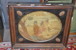A 19th Century needlework picture of three ladies in a country landscape set in an oval surround and