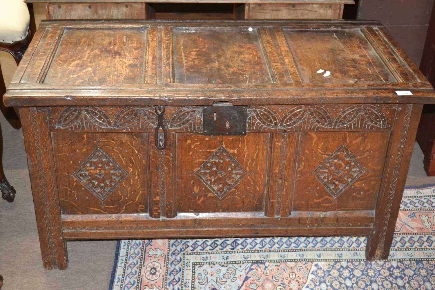 18th Century oak coffer with panelled top, hinged lid and carved decoration to the front, 109cm