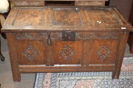 18th Century oak coffer with panelled top, hinged lid and carved decoration to the front, 109cm