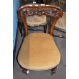 A Victorian bar back walnut nursing chair with carved floral decoration and upholstered seat