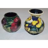 A Moorcroft vase with tubelined floral design together with a further small ase with a pansy type