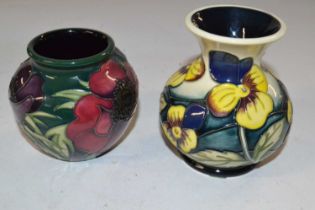 A Moorcroft vase with tubelined floral design together with a further small ase with a pansy type