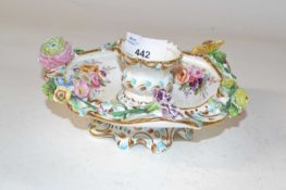 A 19th Century porcelain candle holder painted with floral sprays and flowers in relief