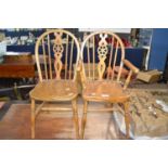 A miniature wheel back elm seated carver chair together with a matching side chair, 60cm high (2)