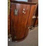 A George III mahogany bow front two door wall mounted corner cabinet with shelved interior, 110cm