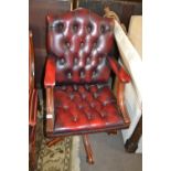 A red leather upholstered revolving office chair