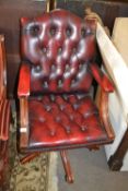 A red leather upholstered revolving office chair