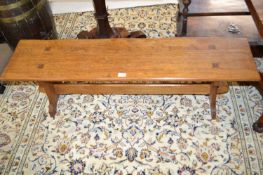 An oak Arts & Crafts style low bench of plain form, the end carved with a mouse, 127cm long