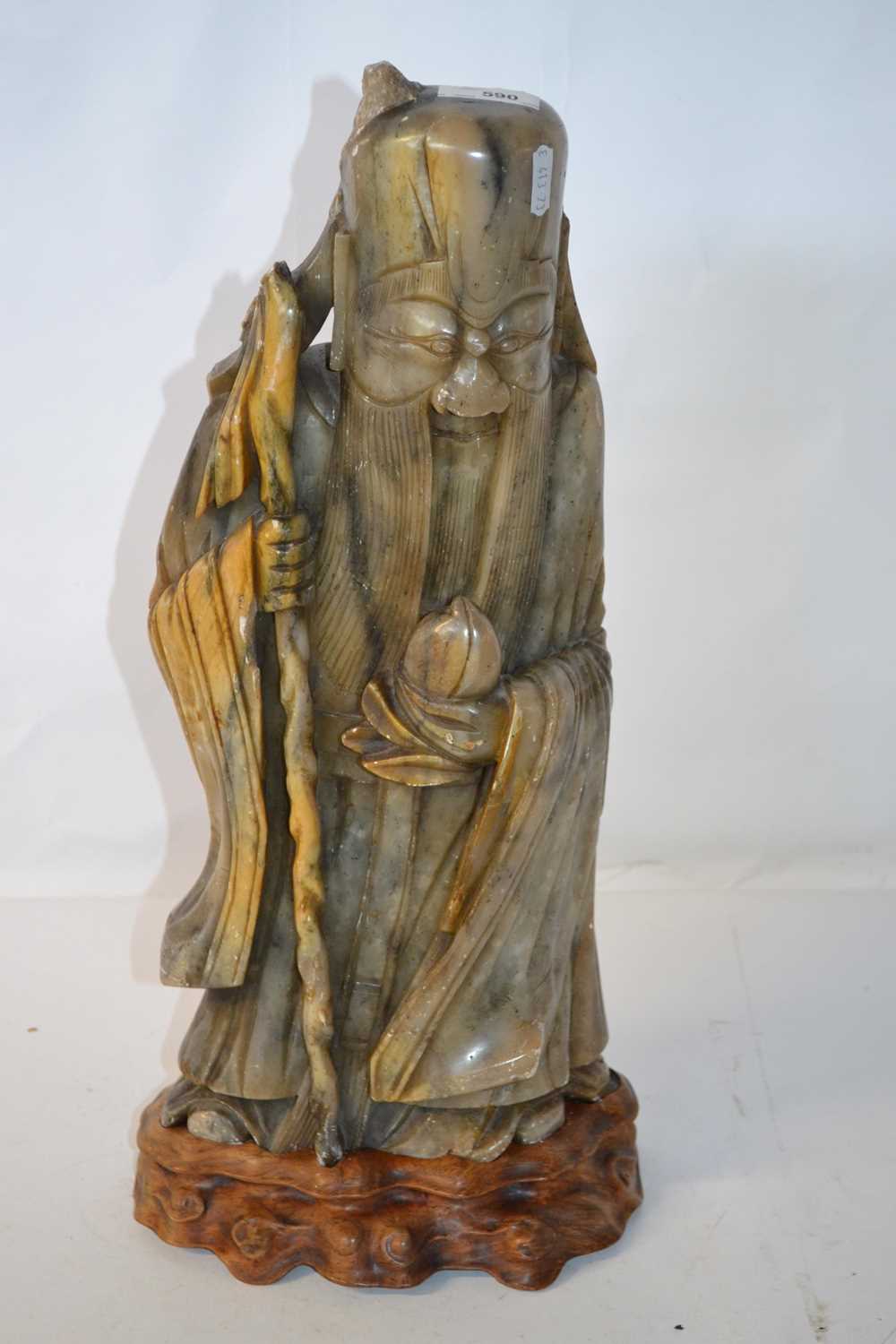 A Chinese polished stone model of a sage, set on a turned wooden plinth, some losses throughout,
