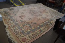 A large Chinese pink washed wool carpet decorated with floral detail and motifs