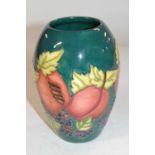 A Moorcroft vase of baluster form with tubelined fruit and flower decoration on green ground, 14cm