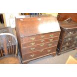 A George III oak bureau of typical form with full front opening to a fitted interior, over a four