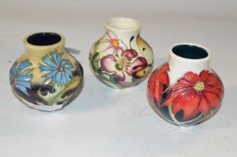 Group of three small Moorcroft vases all with typical floral designs