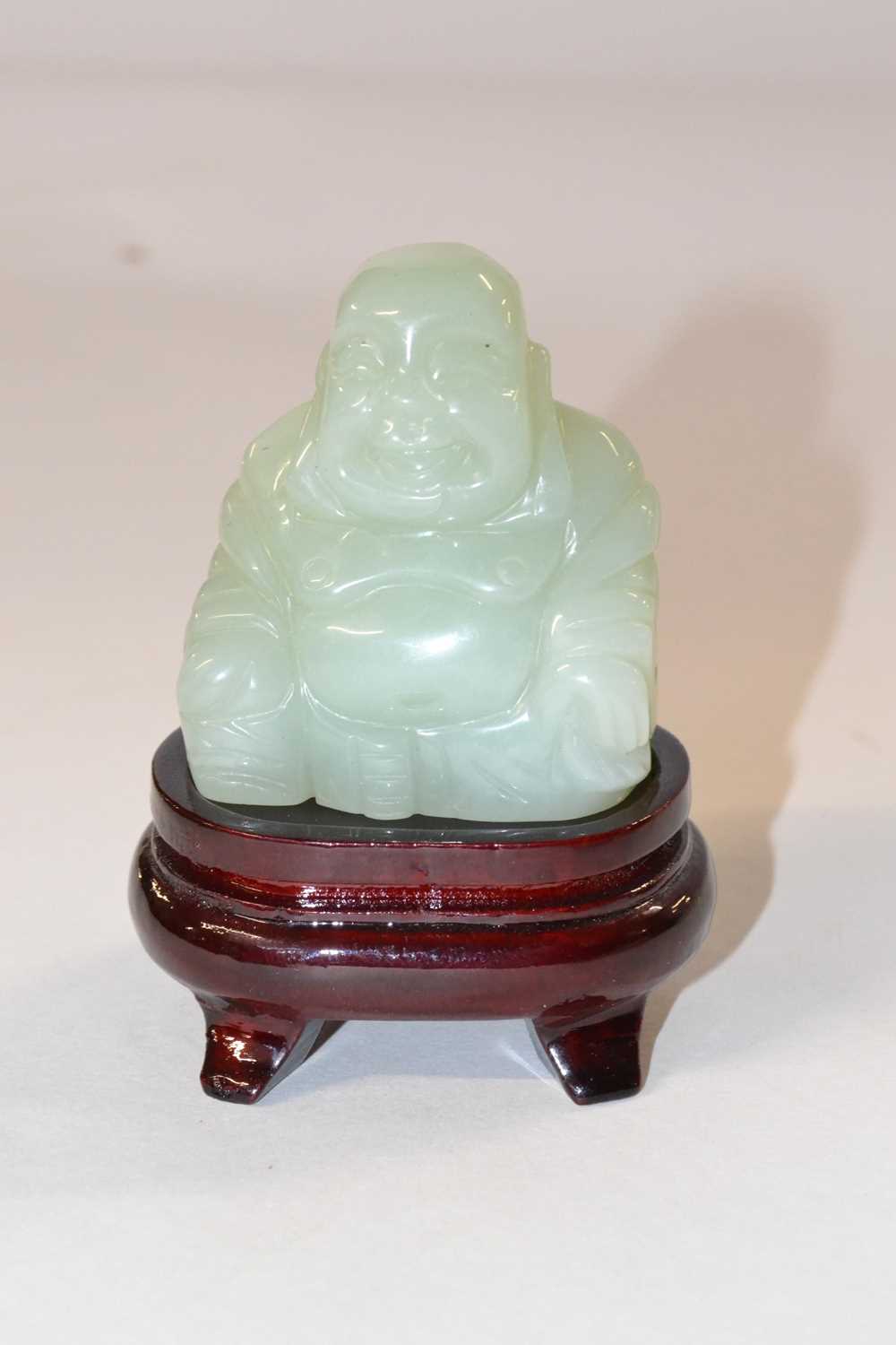 A jadite figure of a Buddha on wooden stand