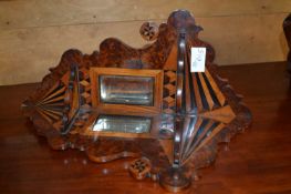 A small 19th Century mirrored wall bracket decorated with a multiwood venered geometric design -