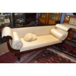 A large late regency mahogany framed sofa with scrolled ends and bolster cushions supported on