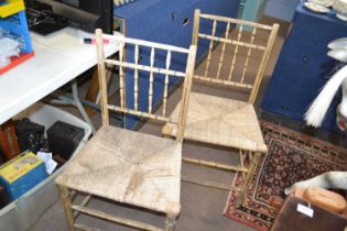 A pair of Georgian faux bamboo and rush seated chairs of typical form, requiring restoration, 89cm