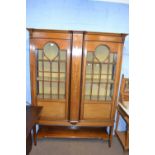 An Edwardian mahogany and inlaid display cabinet with two glazed doors opening to a fabric lined
