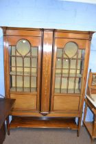 An Edwardian mahogany and inlaid display cabinet with two glazed doors opening to a fabric lined