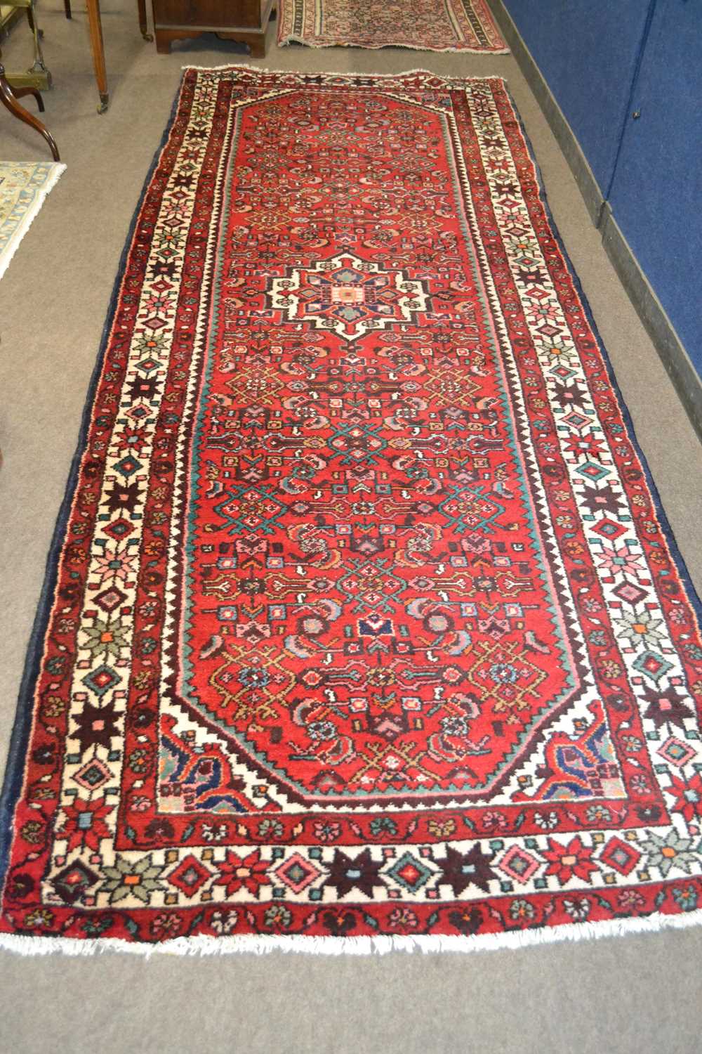 A Turkish wool runner carpet with large central medallion surroumded by a close geometric pattern on