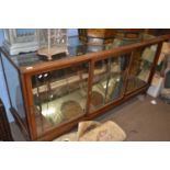 An early 20th Century shop display cabinet with sliding glass doors, 178cm long - NOTE: Glass to top