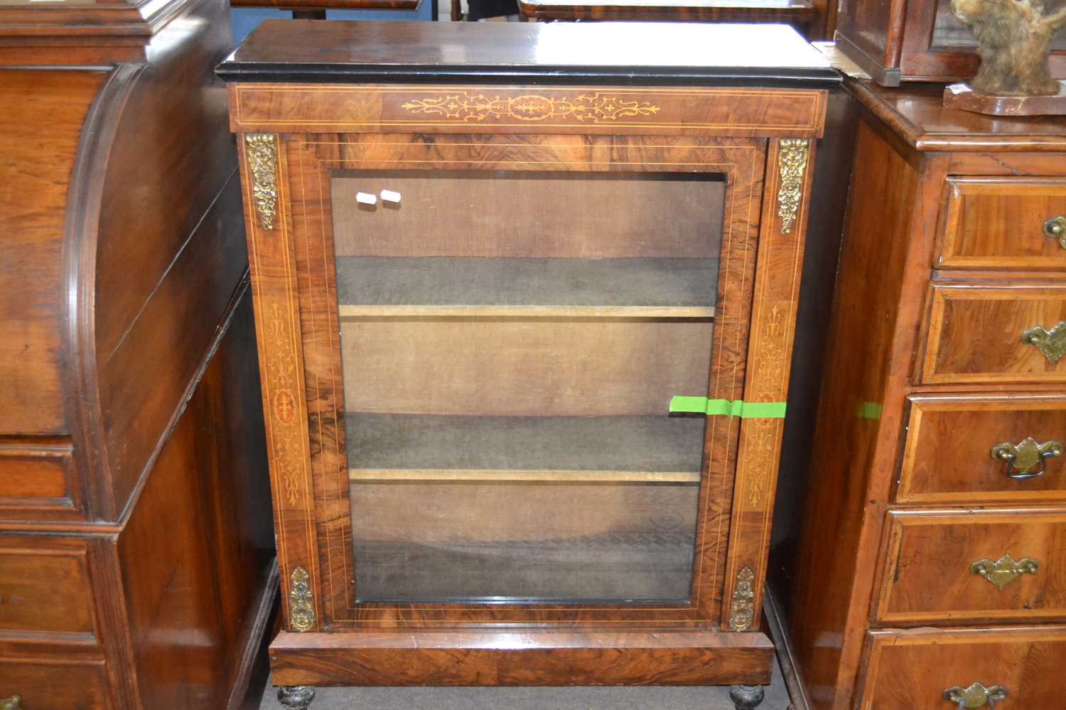 A Victorian walnut veneered pier cabinet with single glazed door, fabric lined shelved interior,