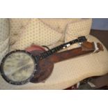 An antique banjo with six strings, stamped to the reverse of the head, J E Dallas Maker, 92cm long
