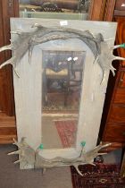 A contemporary wall mirror with antler mounts, 110cm high