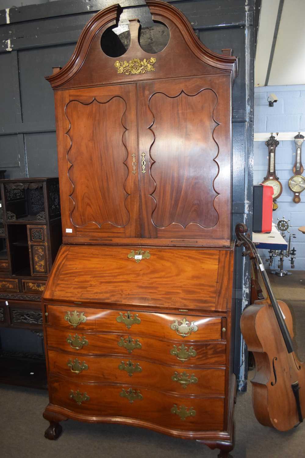 A large 18th Century American bureau bookcase, the top section with swept broken arch pediment