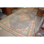 An early 20th Century Persian wool carpet with intense geometric pattern in faded blue, pink and