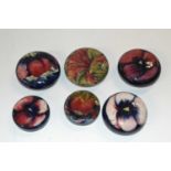 A group of six early 20th Century Moorcroft pottery lids, one with a cornflower design, others