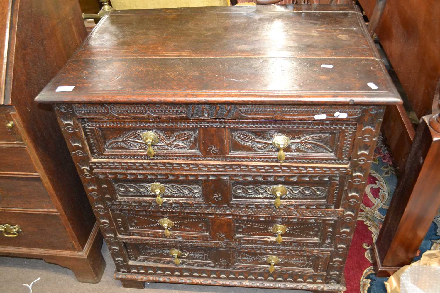 A 17th Century oak chest of drawers with panelled ends and four drawers with carved decoration