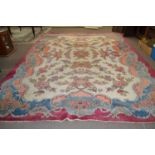 An early 20th Century wool carpet with all over rose decoration and large central cartouche